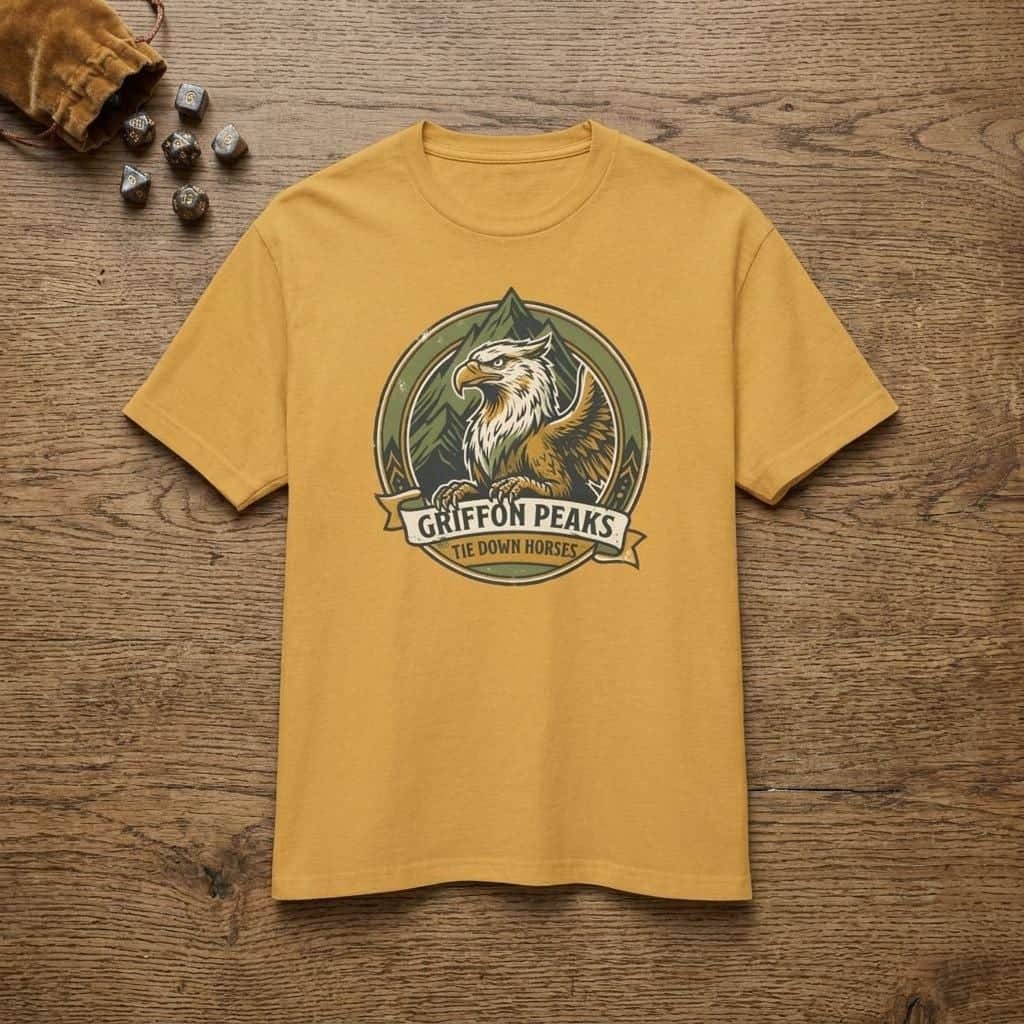 Photo 2 of 15: Vintage national park parody tee featuring a noble mountain griffon alongside a deadpan ranger warning for traveling adventurers to keep their prized mounts secured, shown laid flat among dice