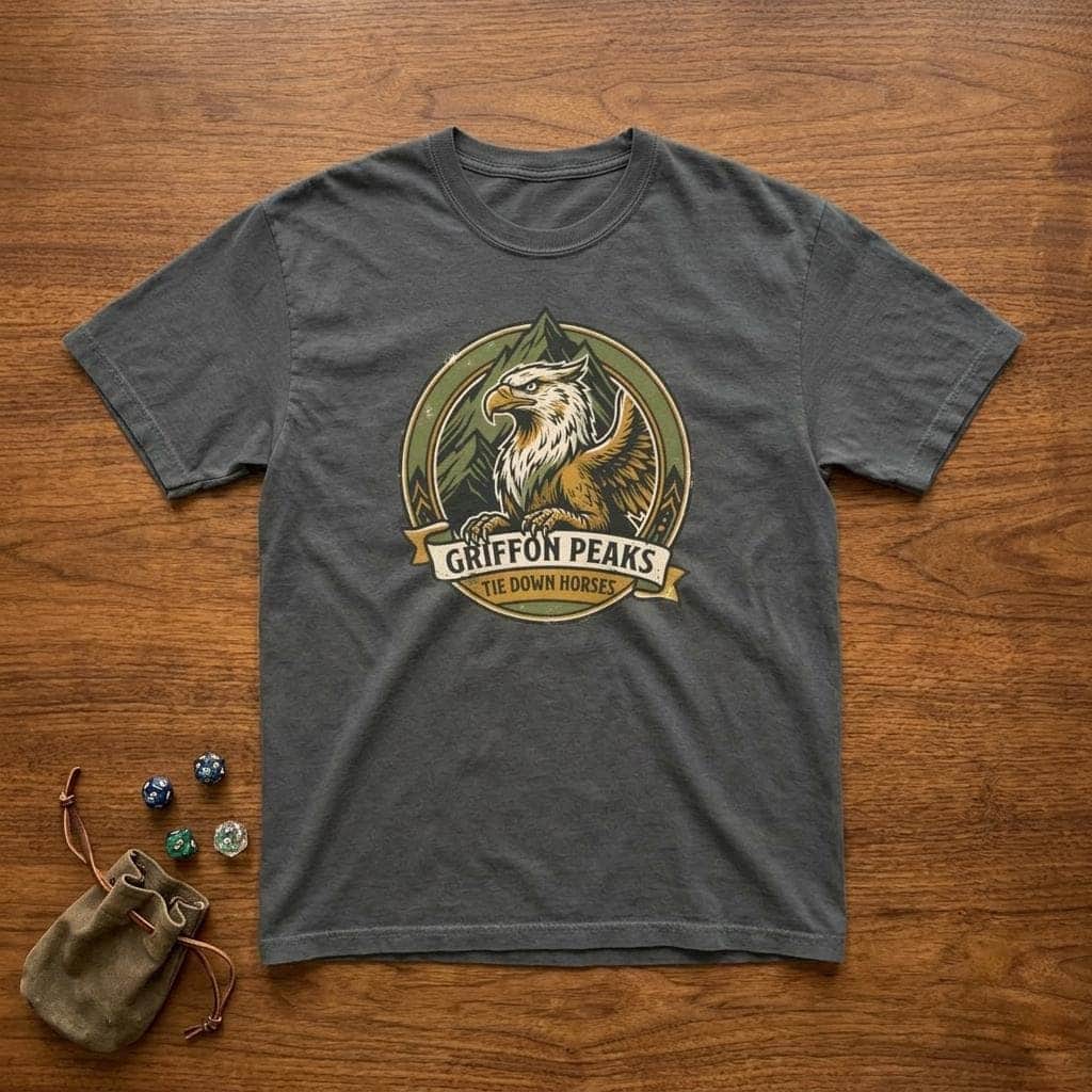 Photo 1 of 15: Vintage national park parody tee featuring a noble mountain griffon alongside a deadpan ranger warning for traveling adventurers to keep their prized mounts secured, shown laid flat among dice