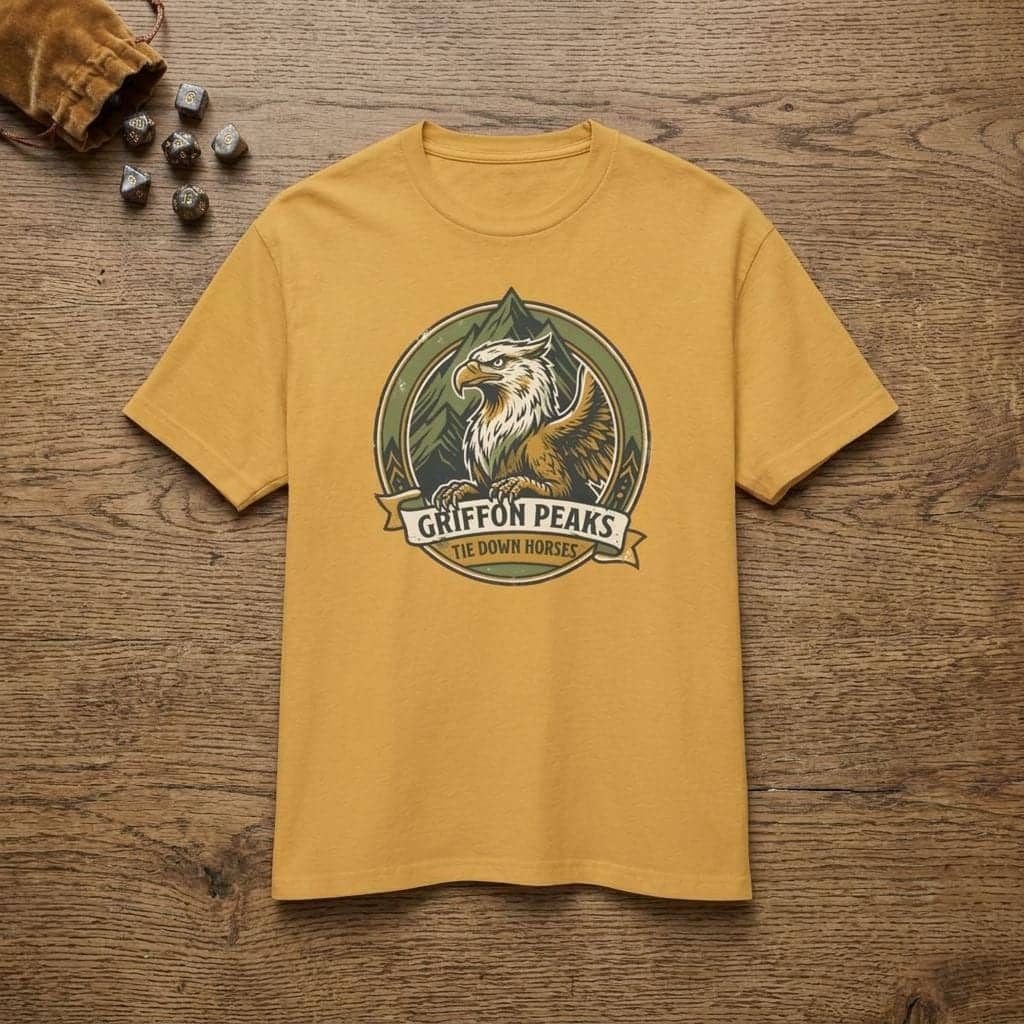 Vintage national park parody tee featuring a noble mountain griffon alongside a deadpan ranger warning for traveling adventurers to keep their prized mounts secured, shown laid flat among dice