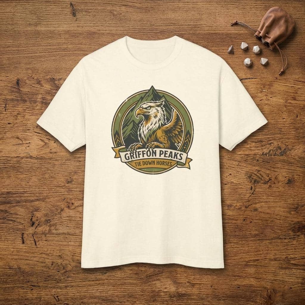 Vintage national park parody tee featuring a noble mountain griffon alongside a deadpan ranger warning for traveling adventurers to keep their prized mounts secured, shown laid flat among dice
